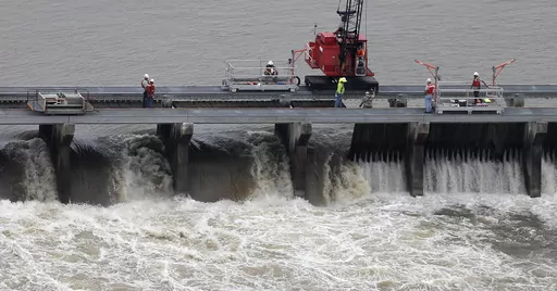 Workers open bays of the Bonnet Carre Spillway to divert rising water from the Mississippi River to Lake Pontchartrain, upriver from New Orleans, in Norco, La., May 10, 2019. Several local governments and business groups on the Mississippi Gulf Coast filed a lawsuit Monday, Jan. 22, 2024, saying that the U.S. Army Corps of Engineers' opening of the spillway in 2019 sent polluted fresh water from the Mississippi River into the Gulf of Mexico and killed bottlenose dolphins that live in saltwater. 