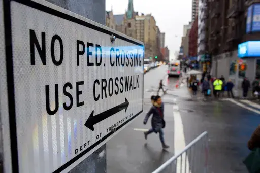 After crossing outside a crosswalk, a pedestrian, center, runs towards a crosswalk at the busy intersection of W. 96th Street and Broadway in the Upper West Side of New York Monday, Jan. 27, 2014. (AP Photo/Craig Ruttle, File)