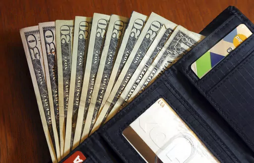 In this June 15, 2018, file photo, cash is fanned out from a wallet in North Andover, Mass. We head into the new year with big plans, hoping this will be the year we whittle down that to-do list and get our money on track. But daily life gets in the way — meetings, appointments, errands and emergencies. (AP Photo/Elise Amendola, File)