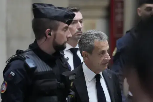 Former French President Nicolas Sarkozy arrives at the courtroom for his appeal trial of trying to bribe a magistrate in exchange for information about a legal case in which he was implicated Monday, Dec. 5, 2022 in Paris. (AP Photo/Francois Mori, File)