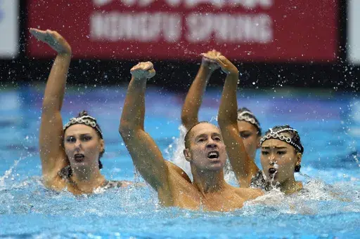 The United Staes team, including Bill May, front left, compete in the team acrobatic of artistic swimming at the World Swimming Championships in Fukuoka, Japan, Saturday, July 15, 2023. May might become the first man to compete in artistic swimming at an Olympics. May, 45, who lives in California, will find out Friday if he is picked by a five-person panel to represent the United States at the Paris Games in the team event for the sport that used to be called synchronized swimming. (AP Photo/Nic