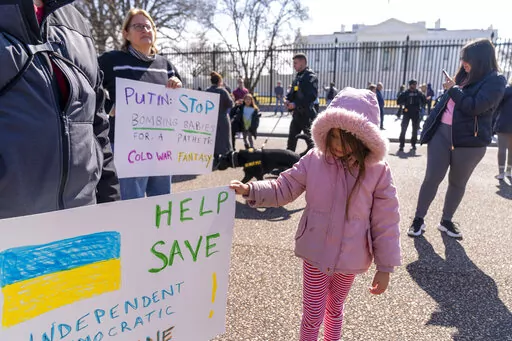 A child joins a small group to protest the Russian invasion of Ukraine in front of the White House in Washington, Friday, Feb. 25, 2022. (AP Photo/Andrew Harnik)