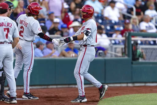 Arkansas' Chris Lanzilli (18) gets five from Jalen Battles (2) after his home run in the second inning against Mississippi during an NCAA College World Series baseball game Wednesday, June 22, 2022, in Omaha, Neb. (AP Photo/John Peterson)