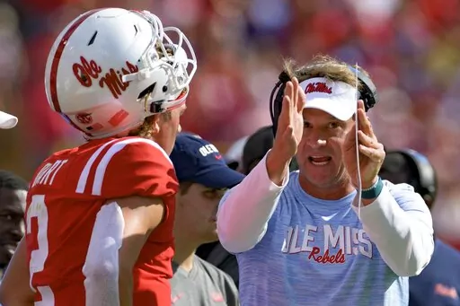 Mississippi head coach Lane Kiffin, right, talks to quarterback Jaxson Dart (2) during the first half an NCAA college football game against LSU in Baton Rouge, La., Saturday, Oct. 22, 2022. (AP Photo/Matthew Hinton)