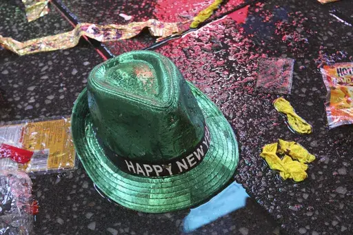 In this Jan. 1, 2019, file photo a "Happy New Year" hat lies on the wet ground along with other items following the celebration in New York's Times Square. (AP Photo/Tina Fineberg, File)