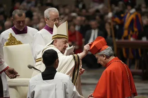 Domenico Battaglia, Archbishop of Naples, Italy, right, receives from Pope Francis, left, the cardinals' hat and ring as he is made cardinal during a solemn mass in St. Peter's Basilica at The Vatican, Saturday, Dec. 7, 2024. (AP Photo/Gregorio Borgia)