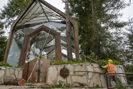 Urban forestry workers remove branches from a redwood tree as they prepare to cut it down next to the Wayfarers Chapel, a sanctuary by architect Lloyd Wright, also known as "The Glass Church," in Rancho Palos Verdes, Calif., Wednesday, May 15, 2024. The modernist chapel features organic architecture with glass walls in a redwood grove overlooking the Pacific Ocean. Part of the Swedenborgian denomination, the church's followers share in 18th-century Swedish scientist and theologian Emanuel Sweden