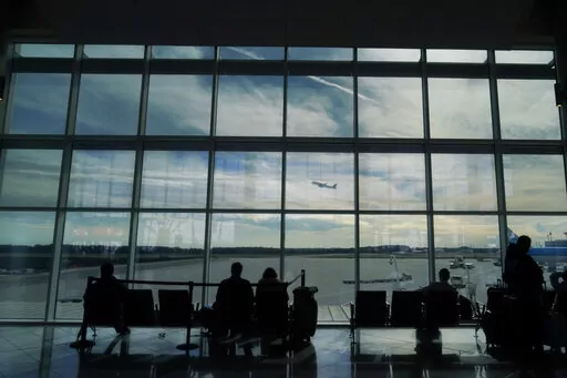Travelers watch as a plane takes off from Hartsfield-Jackson Atlanta International Airport in Atlanta, Tuesday, Nov. 22, 2022. On Friday, Jan. 27, 2023, The Associated Press reported on stories circulating online incorrectly claiming the FAA loosened the requirements that airline pilots must meet for cardiac health because of COVID-19 vaccine side effects. (AP Photo/Brynn Anderson, File)