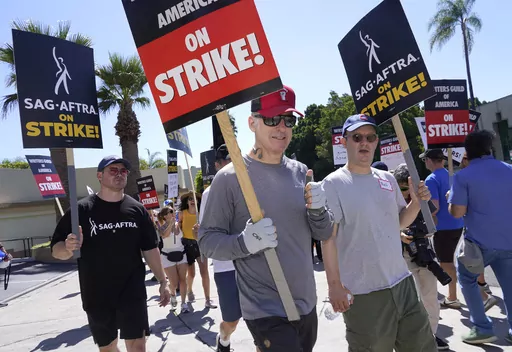Actor Bob Odenkirk, center, carries a sign on a picket line outside Paramount studios on Wednesday, July 19, 2023, in Los Angeles. The actors strike comes more than two months after screenwriters began striking in their bid to get better pay and working conditions. (AP Photo/Chris Pizzello)
