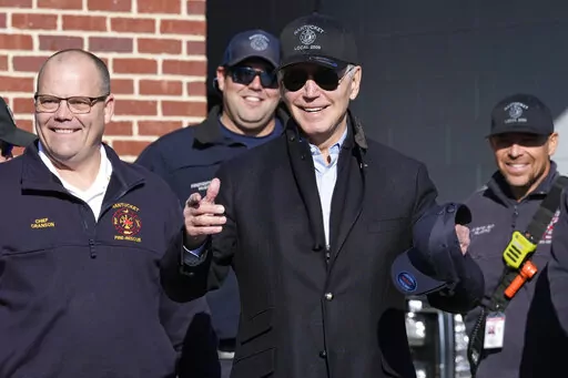 President Joe Biden, center, standing next to Nantucket Fire Department Chief Michael Cranson, left, talks during a visit with firefighters on Thanksgiving Day at the Nantucket Fire Department in Nantucket, Mass., Thursday, Nov. 24, 2022. (AP Photo/Susan Walsh)