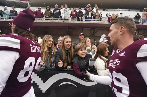 Mississippi State placekicker Massimo Biscardi, right, reaches out to receive congratulatory handshakes from attendees in the Mississippi State Gridiron Club after Mississippi State's win in an NCAA college football game against East Tennessee State, Saturday, Nov. 19, 2022, in Starkville, Miss. The end zones are not necessarily where you will find the cheap seats anymore at college football games. Several colleges have tried making end-zone seating more attractive by turning it into a premium e