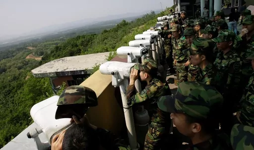 South Korean soldiers look at the North Korean side through binoculars at Dora Observation Post in the demilitarized zone, DMZ, near the border village of Panmunjom that separates the two Koreas since the Korean War, in Paju, north of Seoul, South Korea, Wednesday, May 27, 2009. A series of low-slung buildings and somber soldiers dot the landscape of the DMZ, the swath of land between North and South Korea where a soldier on a tour crossed into North Korea on Tuesday, July 18, 2023, under circum