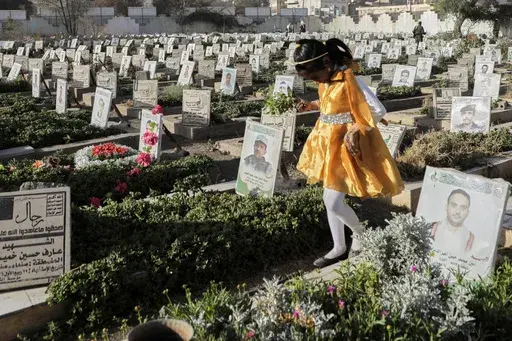 A Yemeni girl visits the graves of Houthis during Eid al-Fitr marking the end of the holy fasting month of Ramadan in Sanaa, Yemen, Sunday, March 30, 2025. (AP Photo/Osamah Abdulrahman)
