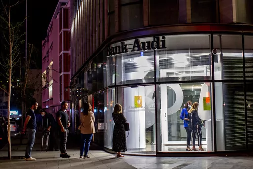 Clients wait to use ATMs outside a closed bank in Beirut, Lebanon, Wednesday, June 2, 2021. Four years into Lebanon's historic economic meltdown, Lebanon's elites are pushing an economic recovery plan that would sidestep critical reforms demanded by the International Monetary Fund. (AP Photo/Hassan Ammar, File)