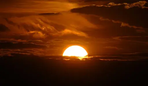 The setting sun illuminates the clouds over the Rocky Mountains after a third straight day of record-breaking heat Sunday, July 14, 2024, in Denver. (AP Photo/David Zalubowski)
