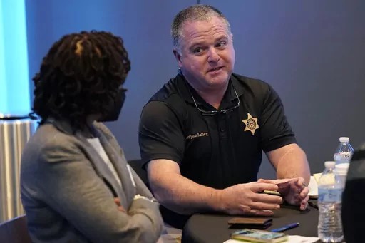 Rankin County Sheriff Bryan Bailey, right, speaks to an attendee at an employer engagement forum in Jackson, Miss., Nov. 4, 2021. Bailey, the Mississippi sheriff who leads the department where former deputies pleaded guilty to a long list of state and federal charges for the racist torture of two Black men has asked a federal court to dismiss a civil lawsuit against him, Friday, Oct. 6, 2023. (AP Photo/Rogelio V. Solis, File)