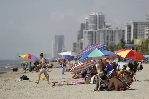 People sit on Hollywood Beach on July 2, 2020, in Hollywood, Fla. (AP Photo/Lynne Sladky, File)