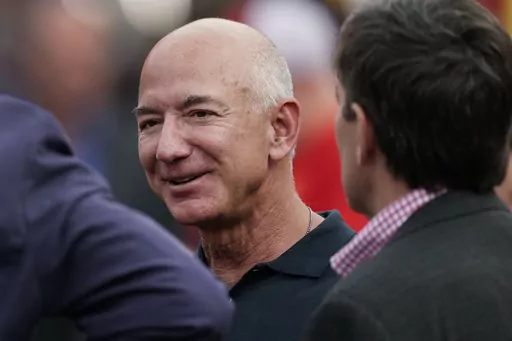 Amazon founder Jeff Bezos is seen on the sidelines before the start of an NFL football game, Sept. 15, 2022, in Kansas City, Mo. The founder of Amazon is buying a home on an exclusive barrier island in Miami where he'll be neighbors with Tom Brady, Ivanka Trump and her husband, Jared Kushner. (AP Photo/Charlie Riedel, File)
