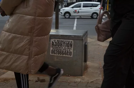 Women pass a sticker advertising abortion pills on a sidewalk in Johannesburg, Wednesday June 28, 2023. When the U.S. Supreme Court overturned the national right to an abortion a year ago, it shook efforts to legalize and make abortions safer in Africa. Sub-Saharan Africa has the world's highest rate of unintended pregnancies, and 77% of abortions are estimated to be unsafe. (AP Photo/Denis Farrell)