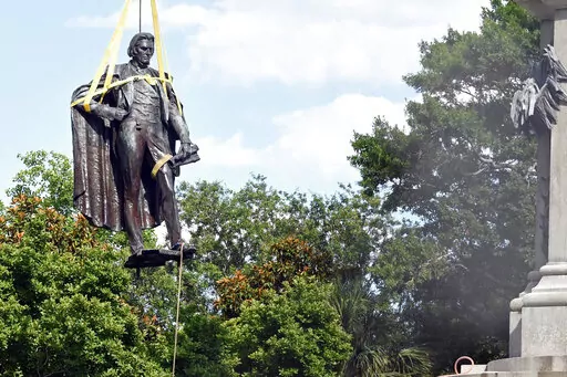 A statue of former U.S. Vice President and slavery advocate John C. Calhoun is raised by crews after its removal from a 100-foot-tall monument on Wednesday, June 24, 2020, in Charleston, S.C. Lawsuits filed to stop the removal of memorials to Confederate leaders and the pro-slavery congressman in a South Carolina city have been dropped. The Post and Courier reports that the American Heritage Association helped fund one of the lawsuits. It had been filed by descendants of John C. Calhoun, a forme