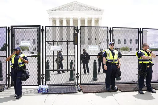 Authorities stand guard by a fence outside the Supreme Court following Supreme Court's decision to overturn Roe v. Wade in Washington, Friday, June 24, 2022. The Supreme Court has ended constitutional protections for abortion that had been in place nearly 50 years, a decision by its conservative majority to overturn the court's landmark abortion cases.(AP Photo/Jacquelyn Martin)