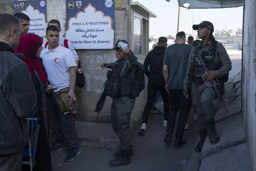 Israeli border police officers check identification cards of Palestinians while they try to cross from the occupied West Bank into Jerusalem, to pray during the holiest night of Ramadan, Laylat al-Qadr, or the "Night of Destiny," when Muslims believe that the Quran was revealed to the Prophet Mohammad, in the Al Aqsa mosque compound, at the Israeli military Qalandiya checkpoint, near Ramallah, Monday, April 17, 2023. Hundreds of thousands of Palestinians are barred from legally crossing into the