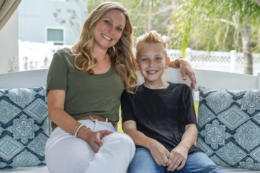 Holly Nover sits with her son, Colton Nover, 10, on a backyard swing at their home Wednesday, Feb. 16, 2022, in St. Johns, Fla. Holly, a speech pathologist active in the National Stuttering Association, said many people will surely be interested in trying stuttering medications – although not her. She is happy with her life as it is and has accepted her stuttering, she said. If her son were struggling and wanted to try medication as a teen, however, she’d be open to the idea. (AP Photo/Fran 