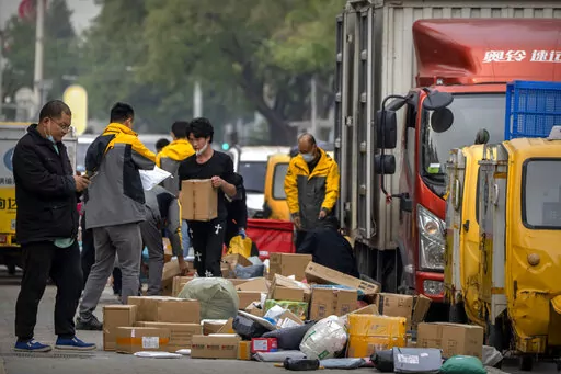 Workers for an express delivery company sort packages along a sidewalk in Beijing, Wednesday, Oct. 12, 2022. A meeting of the ruling Communist Party to install leaders gives President Xi Jinping, China's most influential figure in decades, a chance to stack the ranks with allies who share his vision of intensifying pervasive control over entrepreneurs and technology development. (AP Photo/Mark Schiefelbein)