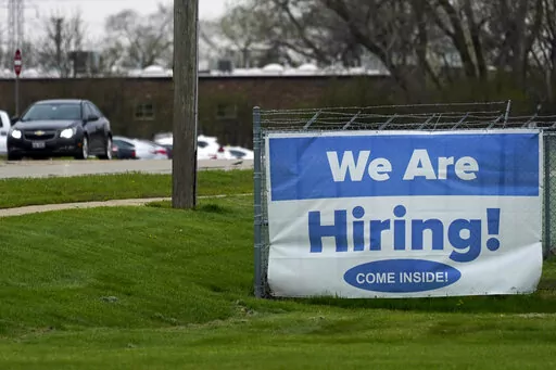 A hiring sign is displayed in Wheeling, Ill., Thursday, May 5, 2022.  America’s employers added 428,000 jobs in April, extending a streak of solid hiring that has defied punishing inflation, chronic supply shortages, the Russian war against Ukraine and much higher borrowing costs.   (AP Photo/Nam Y. Huh)