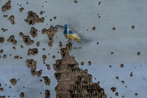 A dove painted by artist TvBoy adorns the wall of a building damaged by Russian shelling attacks in Irpin, Ukraine, Friday, July 7, 2023. Life in the capital of a war-torn country seems normal on the surface. In the mornings, people rush to their work holding cups of coffee. Streets are filled with cars, and in the evenings restaurants are packed. But the details tell another story. (AP Photo/Jae C. Hong, File)