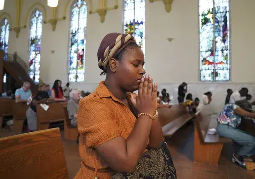 Marie Morette, a congregant of St Raphael Catholic church, prays during Mass in Springfield, Ohio, Sunday, Sept. 15, 2024. (AP Photo/Jessie Wardarski)