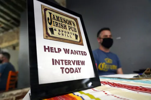 A hiring sign is shown at a booth for Jameson's Irish Pub during a job fair on Sept. 22, 2021, in the West Hollywood section of Los Angeles. California's unemployment rate has fallen to 5.4% after employers added a surprising 138,100 jobs in February. (AP Photo/Marcio Jose Sanchez, File)