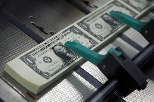 FILE- In this Nov. 15, 2017, file photo, new $1 bills are cut and stacked at the Bureau of Engraving and Printing in Washington. It pays to know the difference between a good 401(k) and a great 401(k). Compared to an average plan, great plans offer features that could potentially lead to tens of thousands of dollars in additional retirement money. Learn the ins and outs of your current 401(k) and compare it to some of the hallmarks of a great 401(k).  (AP Photo/Jacquelyn Martin, File)
