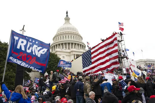 Violent insurrectionists loyal to President Donald Trump stand outside the U.S. Capitol in Washington on Jan. 6, 2021. The public hearings of the House committee investigating the insurrection pose a challenge to Democrats seeking to maintain narrow control of Congress. (AP Photo/Jose Luis Magana, File)