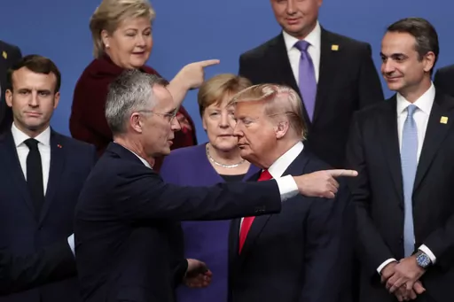 NATO Secretary-General Jens Stoltenberg, front center left, speaks with U.S. President Donald Trump, front center right, after a group photo at a NATO leaders meeting at The Grove hotel and resort in Watford, Hertfordshire, England, Dec. 4, 2019. As Trump becomes the first former president to face federal charges that could put him in jail, many Europeans are watching the case closely. But hardly a single world leader has said a word recently about the man leading the race for the Republican par