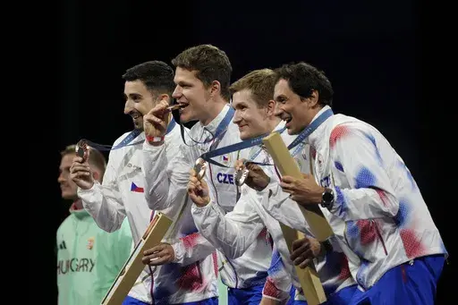 Czech Republic's fencers Jiri Beran, Jakub Jurka, Martin Rubes and Michal Cupr celebrate on the podium after winner the bronze medal in the men's team epee competition during the 2024 Summer Olympics at the Grand Palais, Friday, Aug. 2, 2024, in Paris, France. (AP Photo/Andrew Medichini)