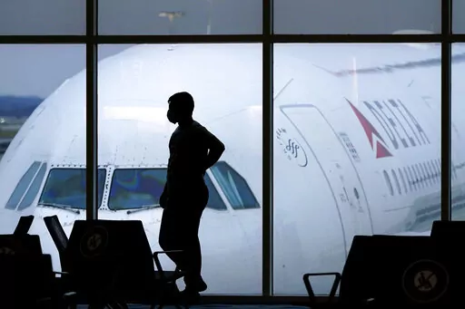 In this Feb. 18, 2021 file photo, a passenger waits for a Delta Airlines flight at Hartsfield-Jackson International Airport in Atlanta. Many airlines, including Southwest Airlines and Delta Air Lines, have resumed full beverage, alcohol and in-flight meal services since cutting refreshment offerings early on in the pandemic. Alcohol, specifically, had possibly gotten the ax as a way to protect flight attendants and passengers alike — both from the spread of the COVID-19 virus and potential inc