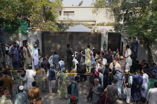 Supporters of former Prime Minister Imran Khan gather outside Khan's residence, in Lahore, Pakistan, Thursday, March 16, 2023. A Pakistani court on Thursday extended a pause for a day in an operation aimed at arresting the former premier Khan, a sign of easing tension in the country's cultural capital of Lahore where 24-hours-long clashes erupted this week when police tried to arrest Khan for failing to appear before a court in the capital. (AP Photo/K.M. Chaudary)