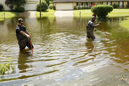 Hinds County, Miss., Emergency Management Operations Deputy Director Tracy Funches, right, and Operations Coordinator Luke Chennault, left, wade through floodwaters in northeast Jackson, Miss., Aug. 29, 2022, as they check water levels. Flooding affected a number of neighborhoods that are near the Pearl River. Environmental groups in Mississippi presented findings Wednesday, Dec. 6, 2023, from the U.S. Army Corps of Engineers showing a long-debated flood control project along the Pearl River wou