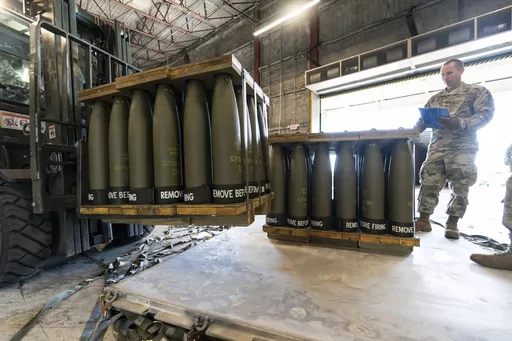 U.S. Air Force Staff Sgt. Cody Brown, right, with the 436th Aerial Port Squadron, checks pallets of 155 mm shells ultimately bound for Ukraine, April 29, 2022, at Dover Air Force Base, Del. On Sept. 15, 2023, The Associated Press reported on a false claim online that the U.S. accidentally sent Ukraine $6 billion in military aid. The claim misrepresents remarks by a Pentagon spokesperson. (AP Photo/Alex Brandon, File)