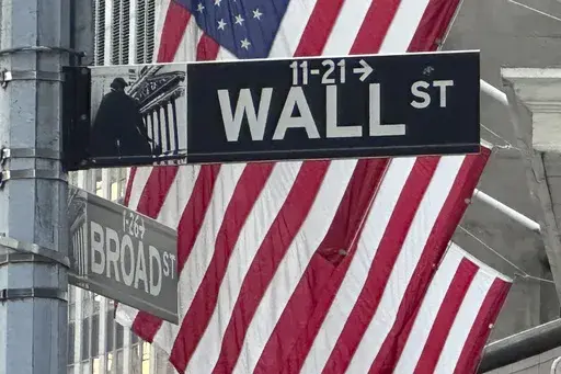 Signs at the intersection of Broad and Wall Streets stand near flags flying from the New York Stock Exchange on Sept. 4, 2024, in New York. (AP Photo/Peter Morgan, File)