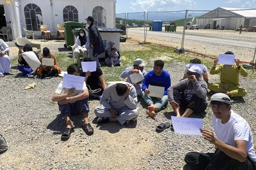 This image provided by Muhammad Arif Sarwari, shows Afghans who fled the Taliban takeover of their country staging a protest at Camp Bondsteel in Kosovo, Wednesday, June 1, 2022. The camp is used to house people who have not been allowed to enter the U.S. because of security concerns. Some of the Afghans have been waiting for months at the base while authorities try to resolve their fate, which officials say may involve sending them to another country for resettlement. (Muhammad Arif Sarwari via