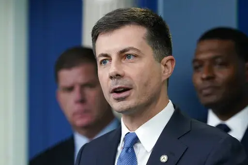 Transportation Secretary Pete Buttigieg, center, speaks during a briefing at the White House in Washington, May 16, 2022, as Labor Secretary Marty Walsh, left, and Environmental Protection Agency administrator Michael Regan, right, listen. Buttigieg says he is pushing airlines to hire more customer-service people and take other steps to help travelers this summer. (AP Photo/Susan Walsh, File)