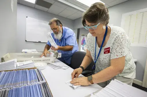 Dawn Stephens, right, and Duane Taylor prepare ballots to be mailed at the Mecklenburg County Board of Elections in Charlotte, N.C., Sept. 5, 2024. (AP Photo/Nell Redmond)