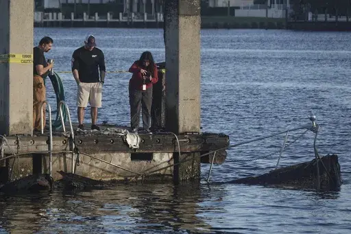 The charred remains of two boats are seen Tuesday, Dec. 24, 2024, at Lauderdale Marina near the 15th Street Fisheries restaurant in Fort Lauderdale, Fla. (Joe Cavaretta/South Florida Sun-Sentinel via AP)