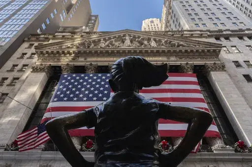 The New York Stock Exchange is shown behind the statue titled "Fearless Girl", Thursday, Dec. 12, 2024, in New York. (AP Photo/Julia Demaree Nikhinson, File)