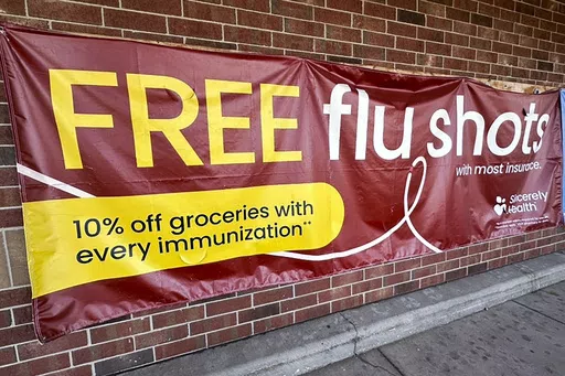 A sign for flu vaccination is displayed outside of a grocery store in Glenview, Ill., Thursday, Feb. 15, 2024. On Friday, April 26, 2024, the Centers for Disease Control and Prevention said last week, for the third straight week, medical visits for flu-like illnesses dipped below the threshold for what's counted as an active flu season. (AP Photo/Nam Y. Huh)