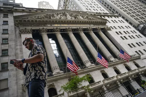 Pedestrians walk past the New York Stock Exchange, on July 8, 2022, in New York.  Stocks are opening lower on Wall Street Wednesday, Aug. 17,  as traders absorb some discouraging news about how much Americans are spending. (AP Photo/John Minchillo, file)