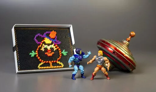 This undated photo provided by The Strong Museum shows the three toys inducted into the National Toy Hall of Fame on Nov. 10, 2022, in Rochester, N.Y. Masters of the Universe, Lite-Brite and the top were chosen from among 12 finalists for the annual honor, which recognizes toys that have inspired creative play and lasting popularity. (Courtesy of The Strong Museum via AP)