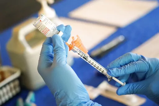 A nurse prepares a syringe of a COVID-19 vaccine at an inoculation station in Jackson, Miss., July 19, 2022. U.S. health officials are proposing a simplified approach to COVID-19 vaccinations, which would allow most adults and children to get a once-a-year shot to protect against the mutating virus. The new system unveiled Monday, Jan. 23, 2023 would make COVID-19 inoculations more like the annual flu shot. Americans would no longer have to keep track of how many shots they’ve received or how 